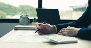 The hand of businessman sit at their desks and calculate financial graphs showing results about